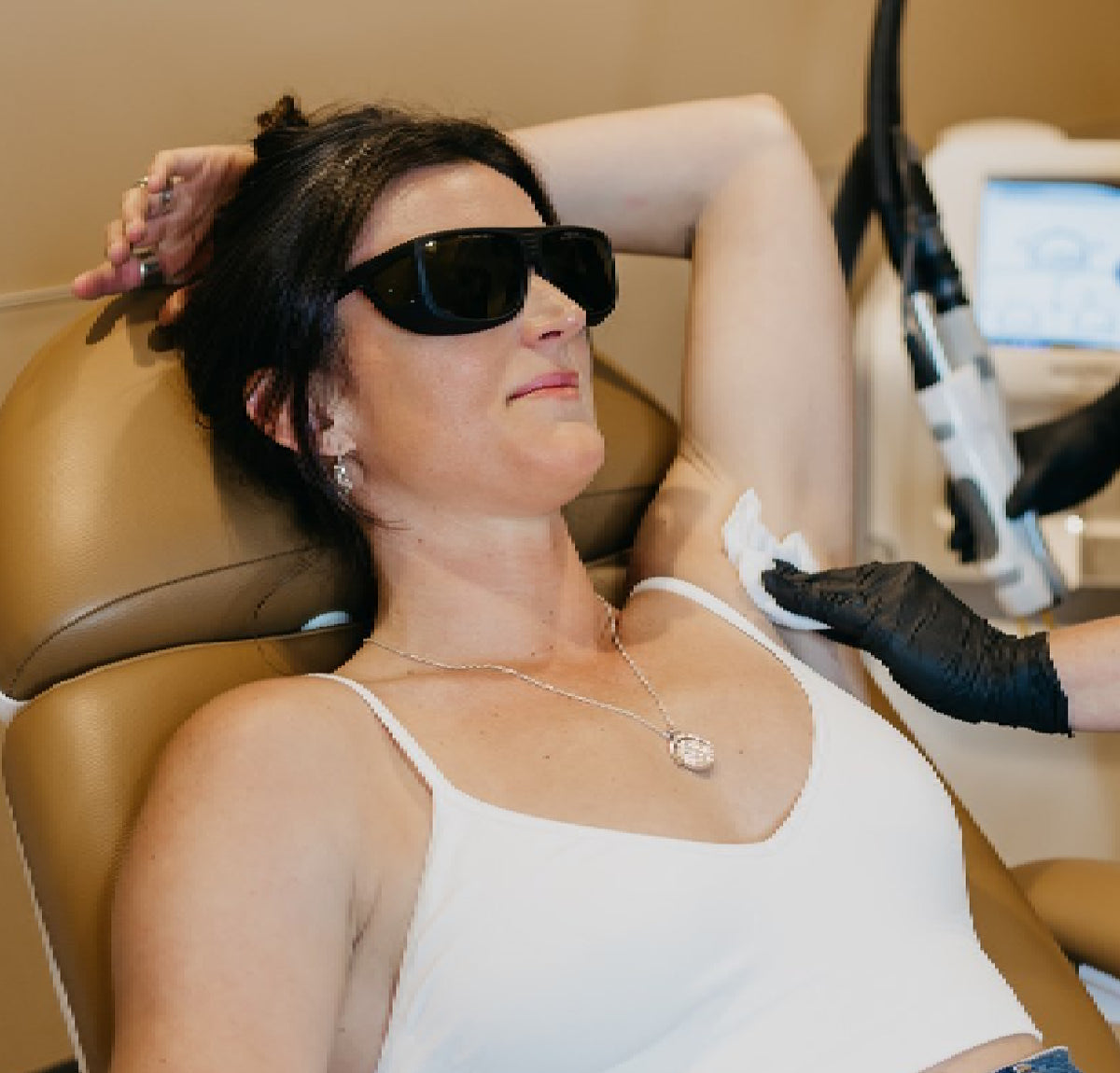 Woman receiving laser treatment in armpit.