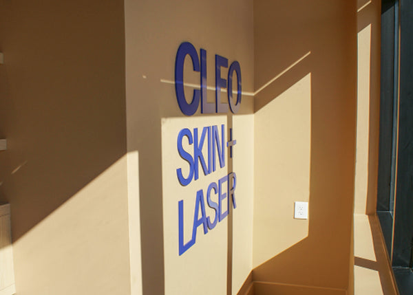 Cleo Skin Laser sign on a beige wall with shelves and a window in the background