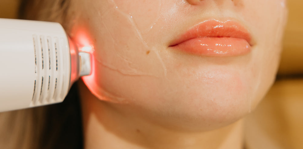 Person receiving facial treatment with tool on cheek