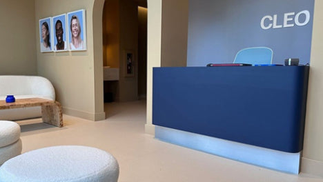 Modern office reception area with a blue desk and 'CLEO' branding.