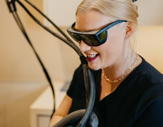 Cleo provider performing tattoo removal with safety glasses on
