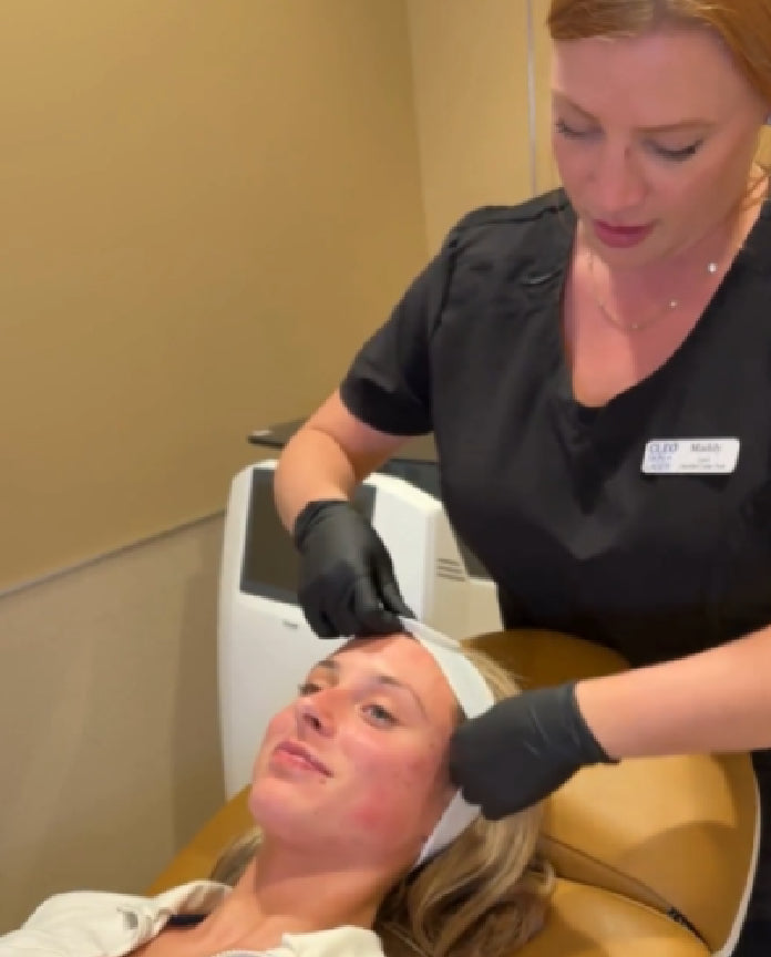 Woman receiving a facial treatment from a professional in a clinical setting.