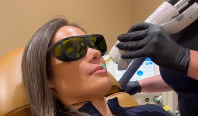 Woman wearing protective glasses and receiving treatment to lip area
